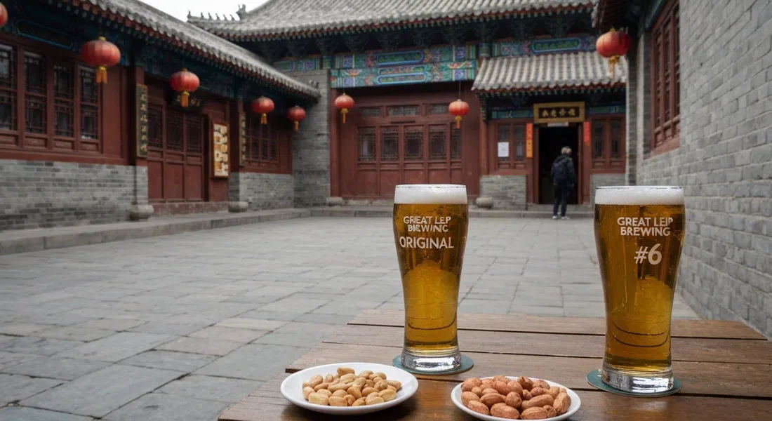 Great Leap Brewing Original #6 en un patio Qing amurallado en Doujiao Hutong, vasos de cerveza sobre adoquines y cacahuetes especiados en la mesa